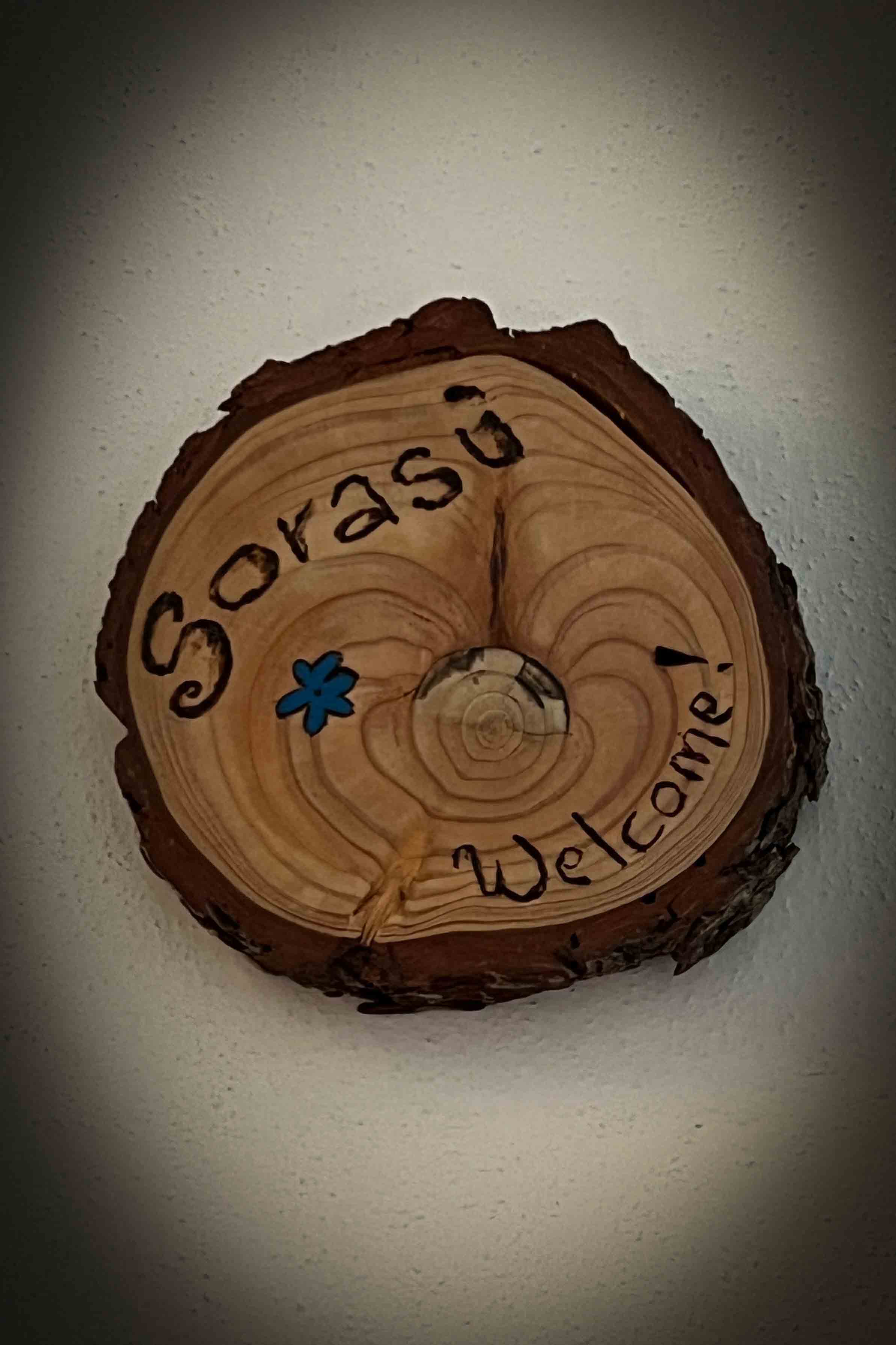 Camera Sorasu. Cartello ingresso elegante in legno.