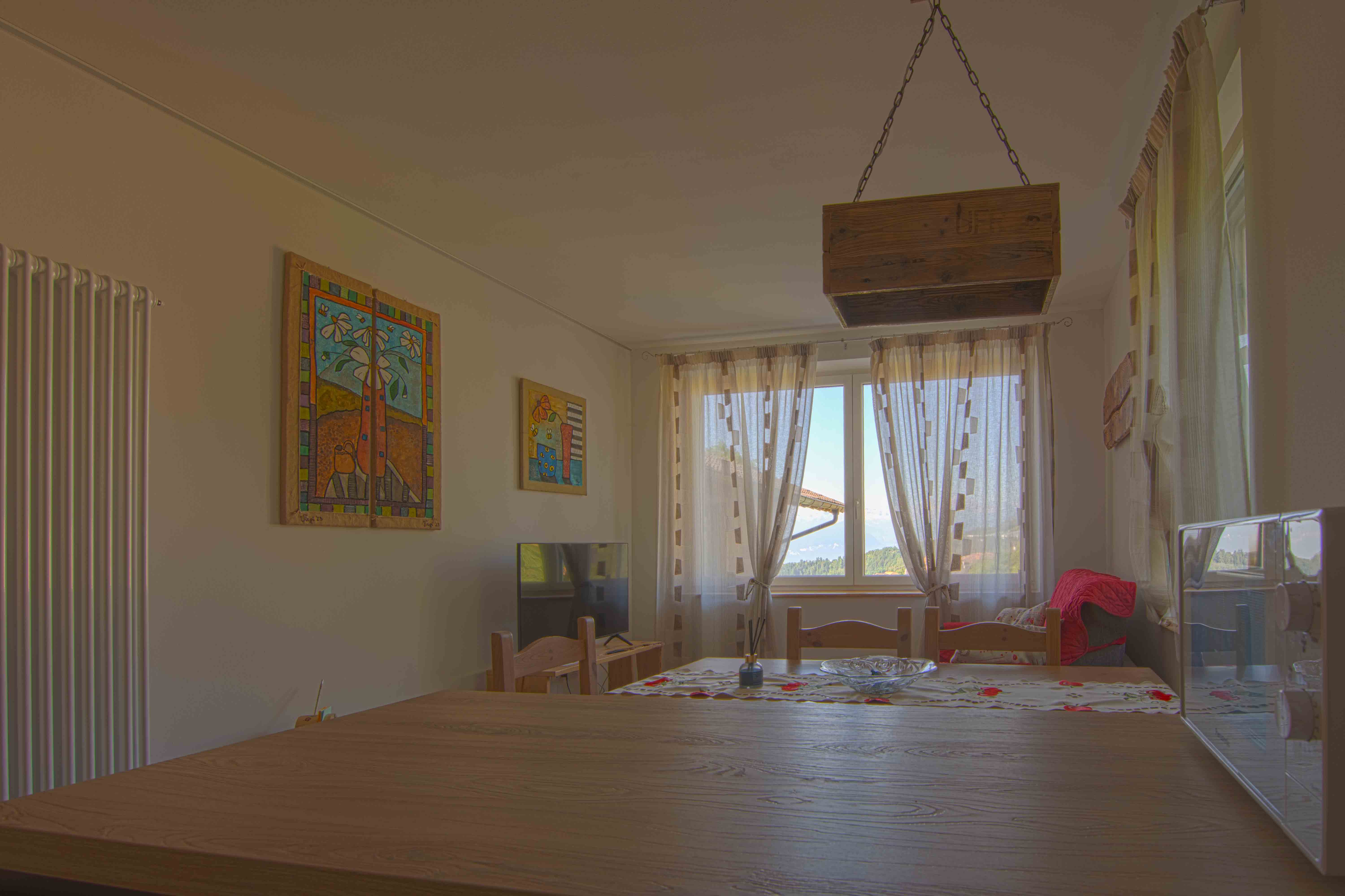 Camera Sous. Spaziosa zona giorno con televisione e eleganti decorazioni in legno.