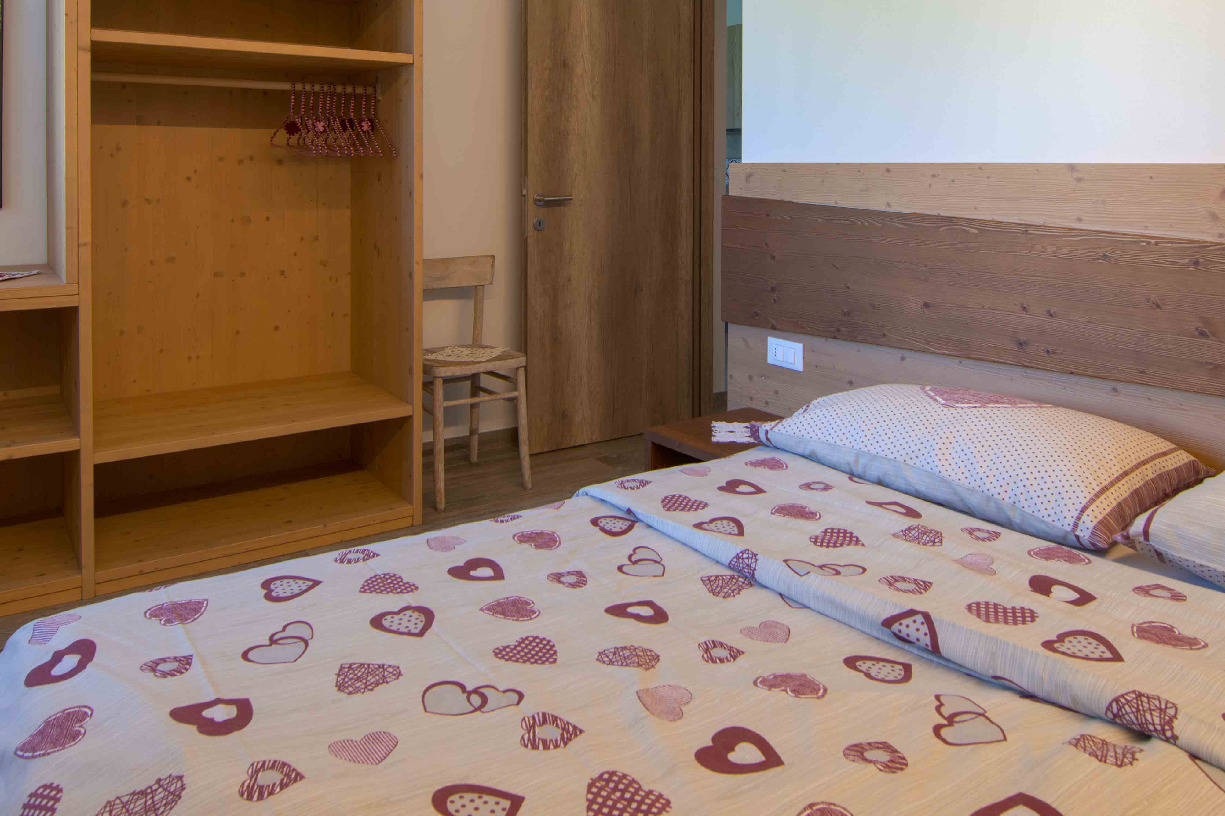 Camera Sous. Romantico letto matrimoniale in camera spaziosa ed elegante con decorazioni in legno.