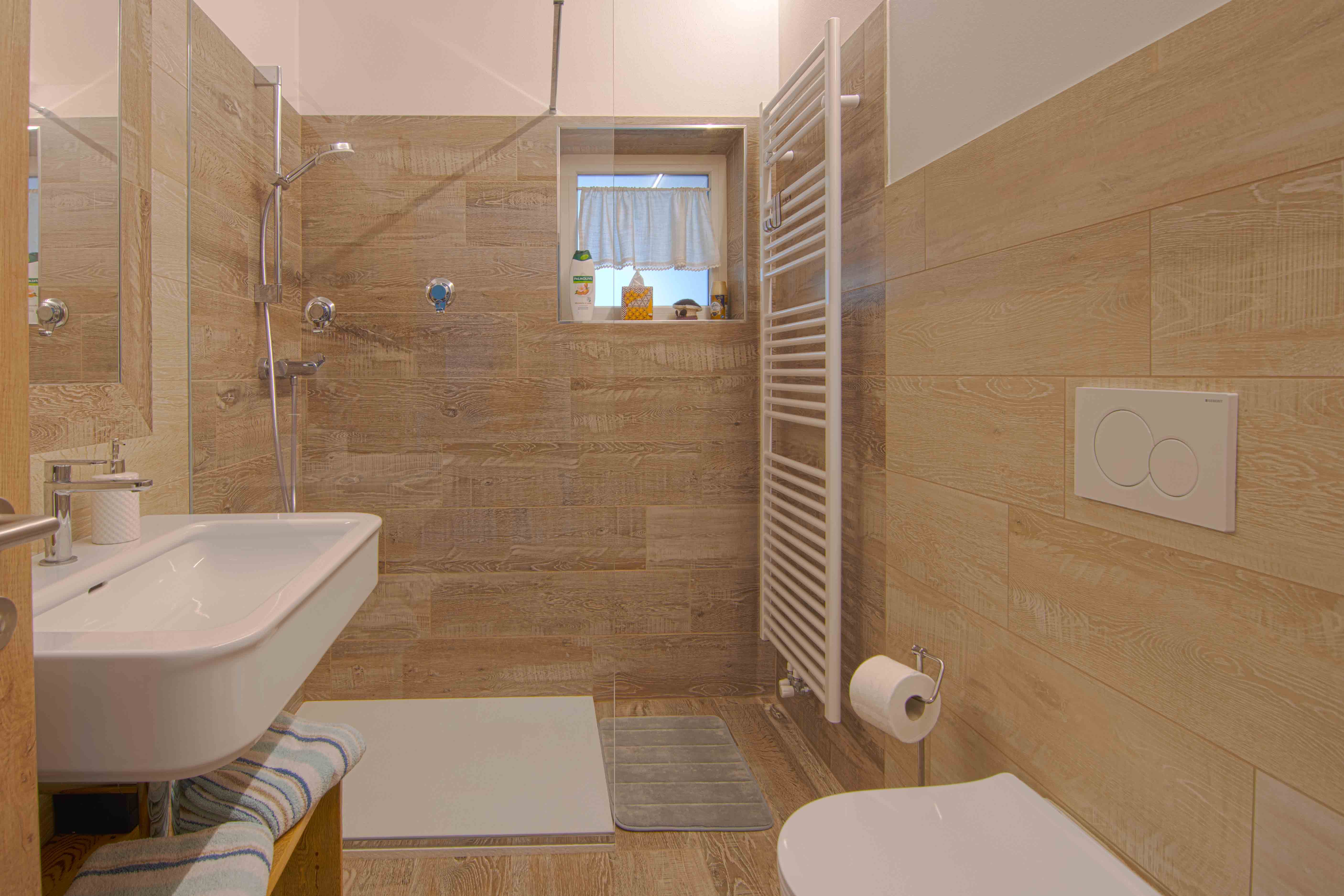 Camera Sous. Spazioso bagno elecante con doccia e decorazioni in legno.