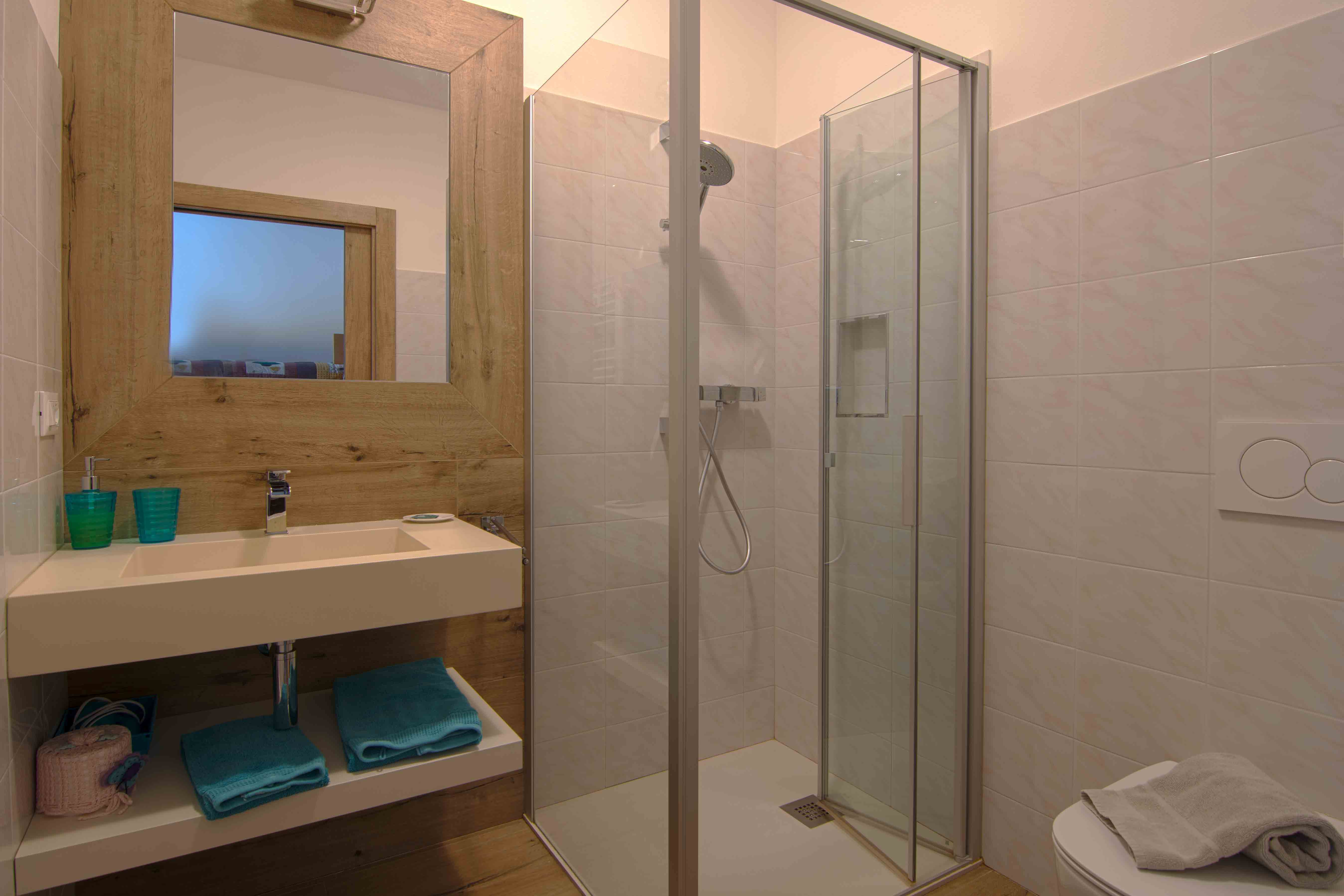 Camera Stagioni. Elegante bagno con doccia e decorazioni in legno.